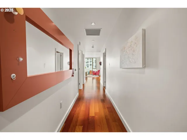 a hallway with wooden floor and chandelier