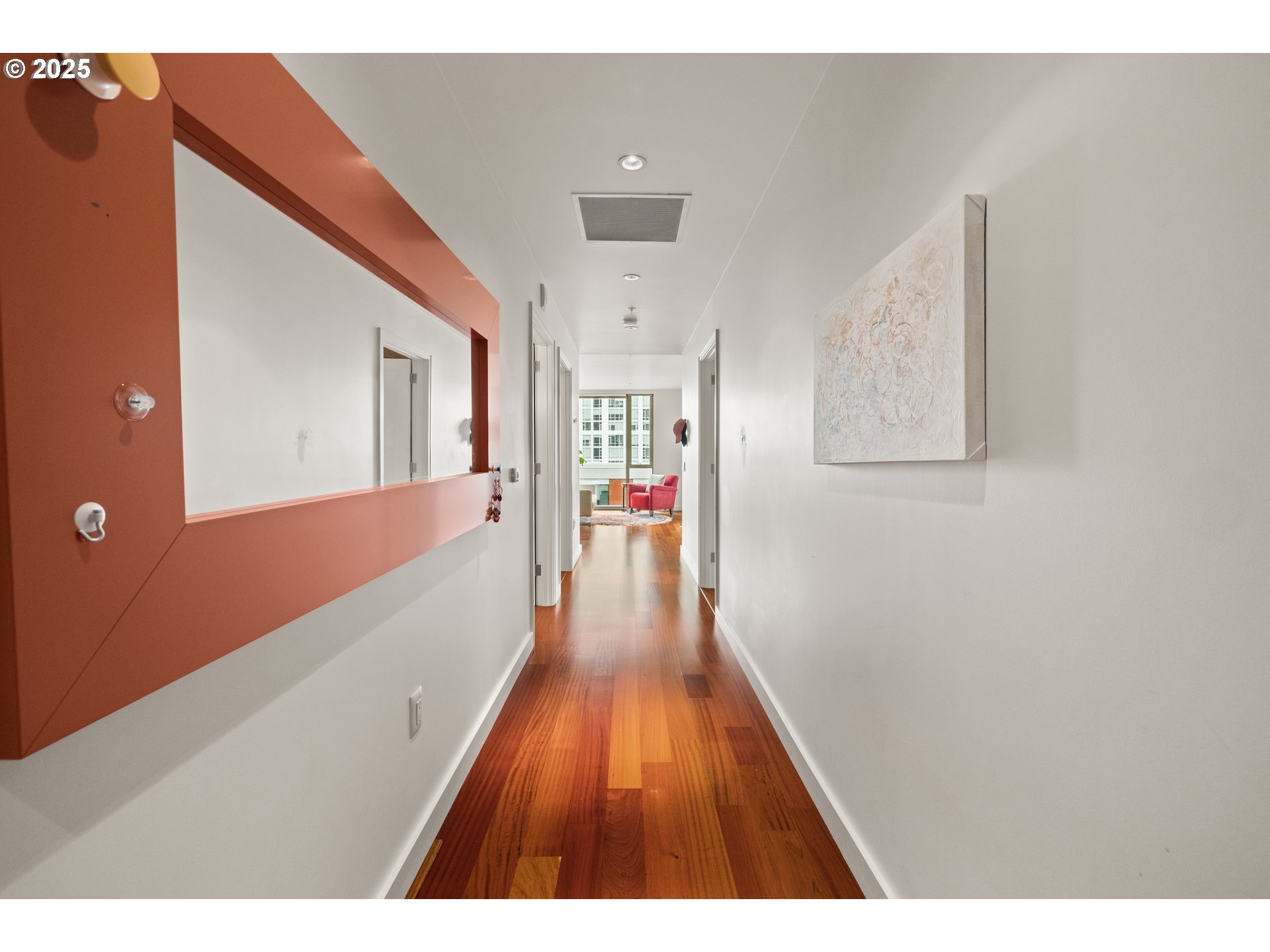 841 Southwest Gaines Street, Unit 714 Portland, OR 97239 - Photo 13 of 48 a hallway with wooden floor and chandelier