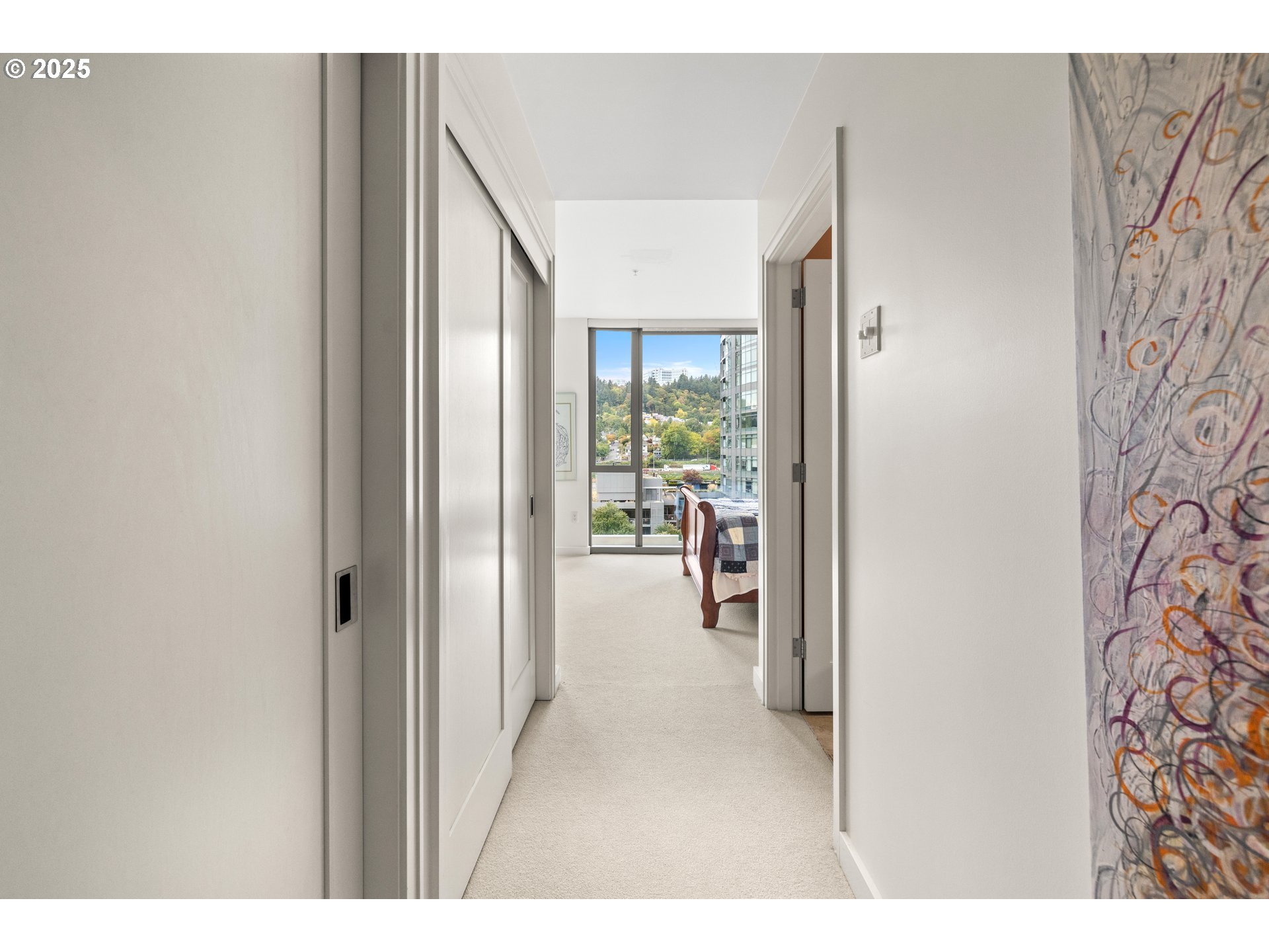 841 Southwest Gaines Street, Unit 714 Portland, OR 97239 - Photo 15 of 48 a hallway with a dining table and a chandelier
