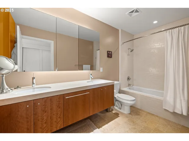 a bathroom with a sink a toilet a mirror and bathtub