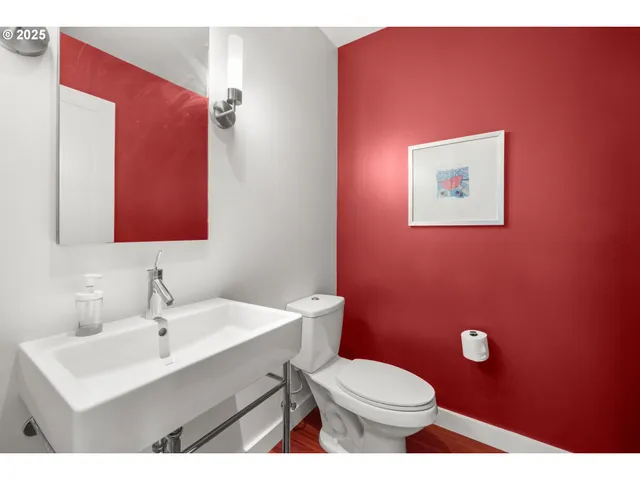 a bathroom with a toilet a sink and mirror