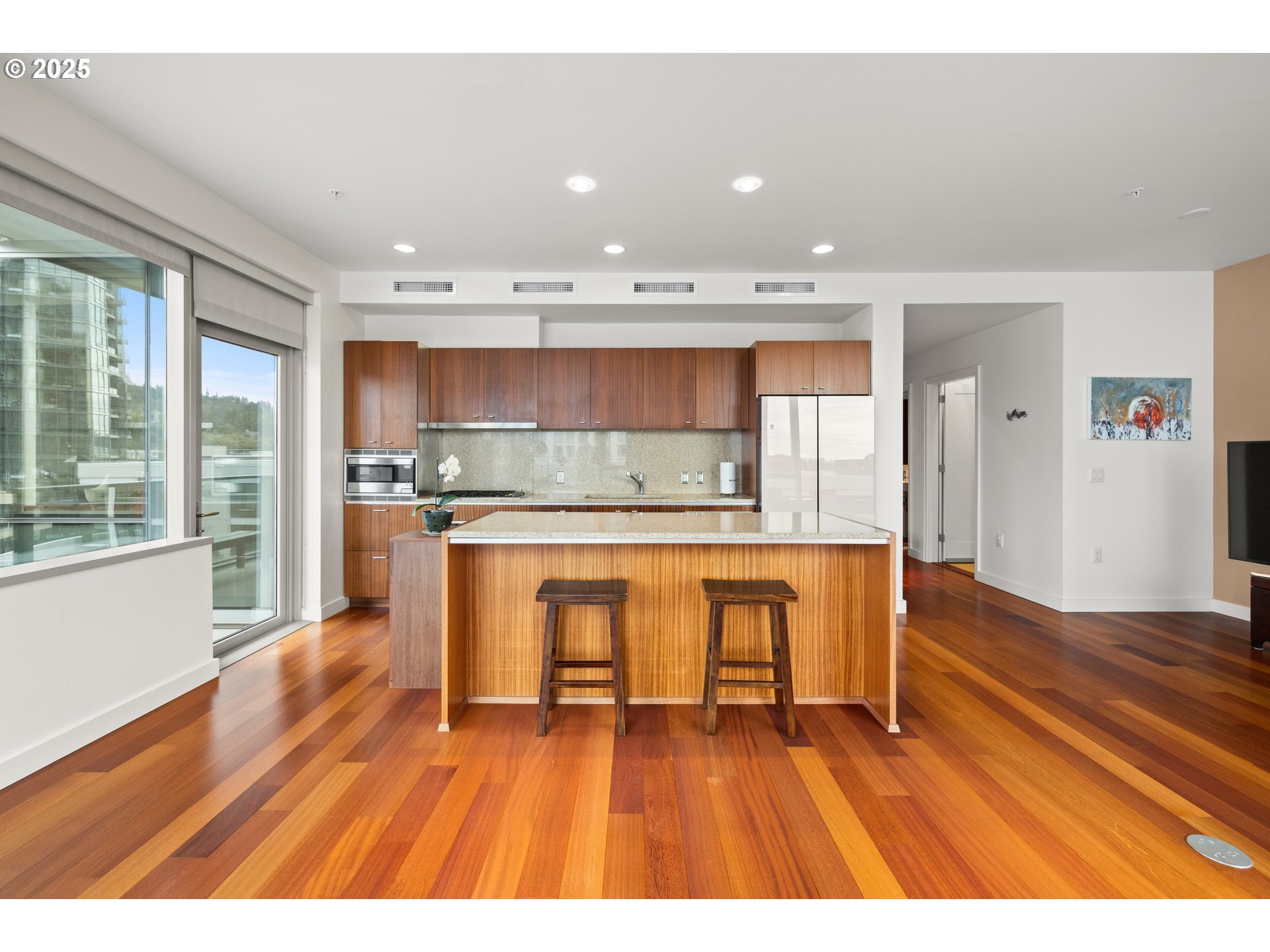 841 Southwest Gaines Street, Unit 714 Portland, OR 97239 - Photo 26 of 48 a room with stainless steel appliances kitchen island wooden floors and wooden cabinets