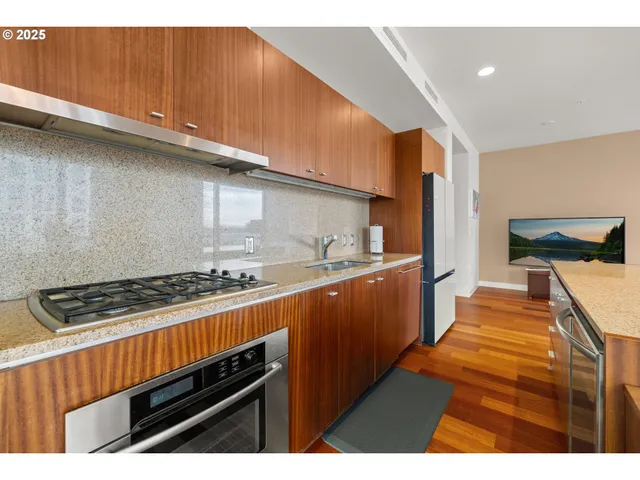 a kitchen with stainless steel appliances a stove a sink and cabinets