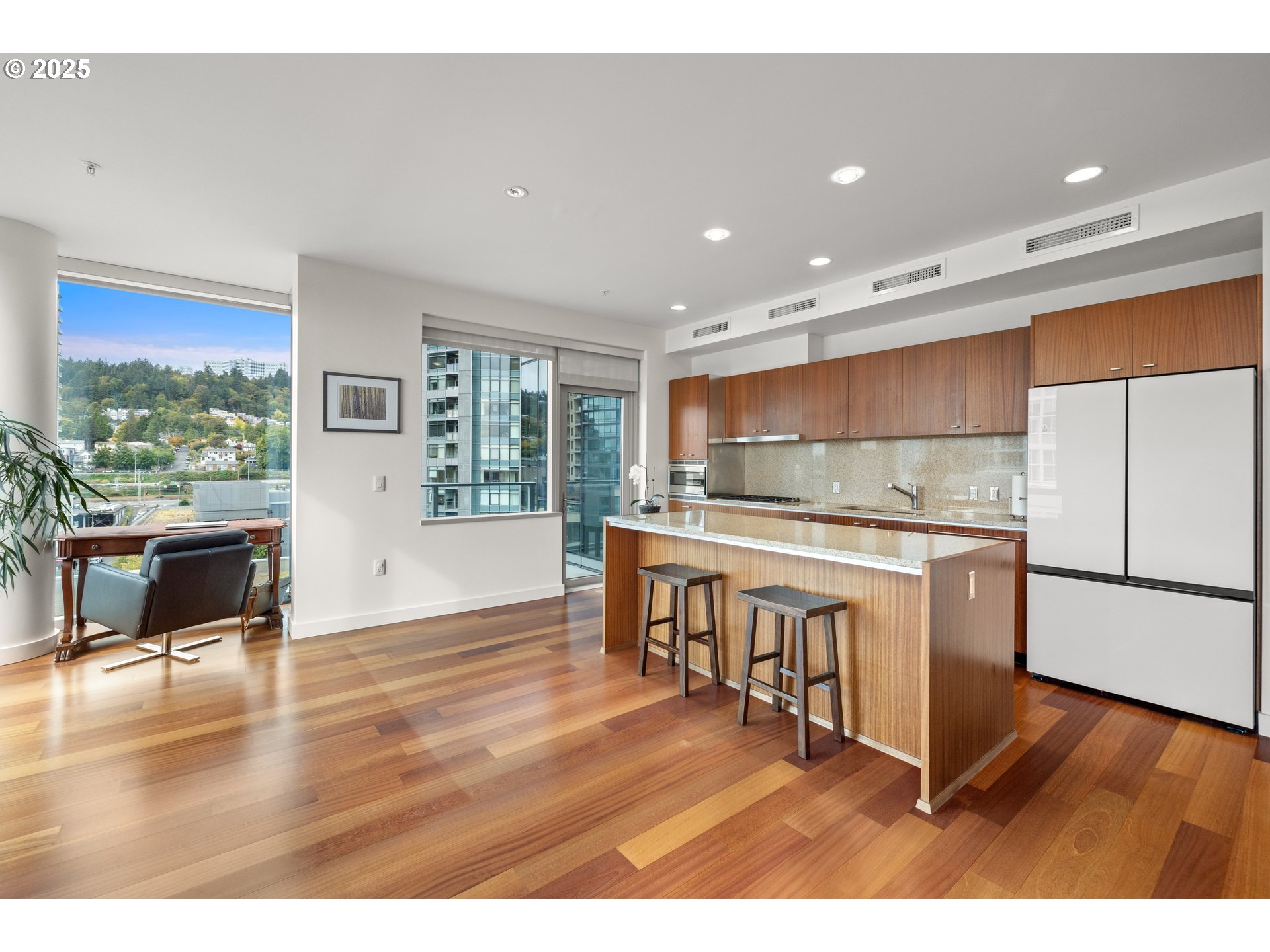 841 Southwest Gaines Street, Unit 714 Portland, OR 97239 - Photo 32 of 48 a kitchen with stainless steel appliances granite countertop a stove top oven a sink and a dining table with wooden floor