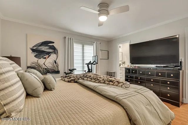 a bedroom with a bed and a flat tv screen on dresser