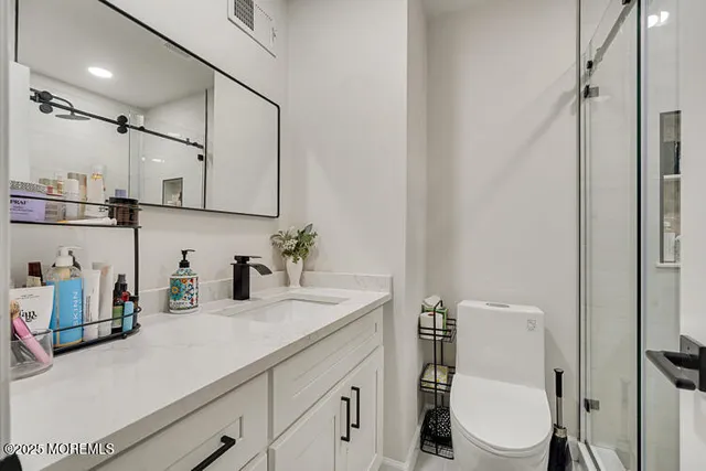 a bathroom with a sink a toilet and shower