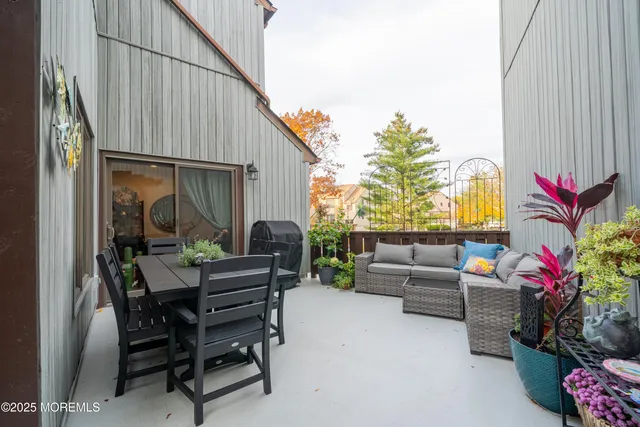 a patio with table and chairs and potted plants