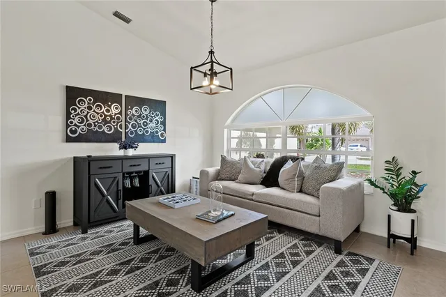 a living room with furniture a chandelier and a table