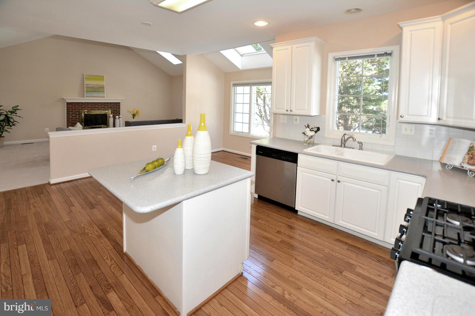 10838 Welbury Court Reston, VA 20194 - Photo 11 of 30 a kitchen with stainless steel appliances a sink dishwasher stove and wooden floor