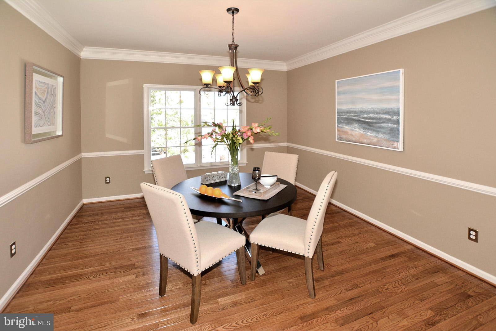 10838 Welbury Court Reston, VA 20194 - Photo 5 of 30 a dining room with furniture a chandelier and wooden floor