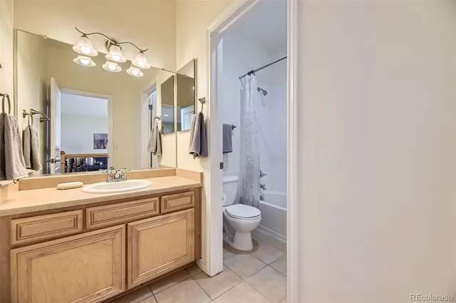 a spacious bathroom with a granite countertop sink a toilet and a mirror