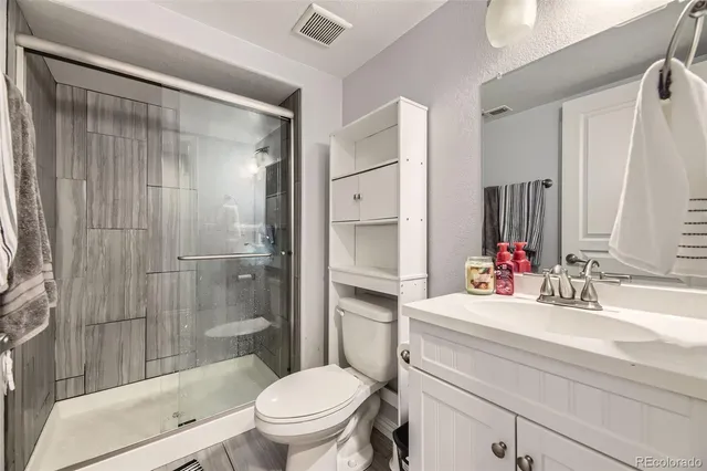 a bathroom with a sink toilet vanity and shower