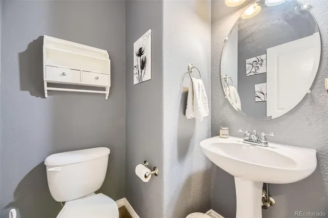 a bathroom with a toilet sink and mirror