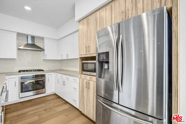 a kitchen with stainless steel appliances a refrigerator sink and microwave