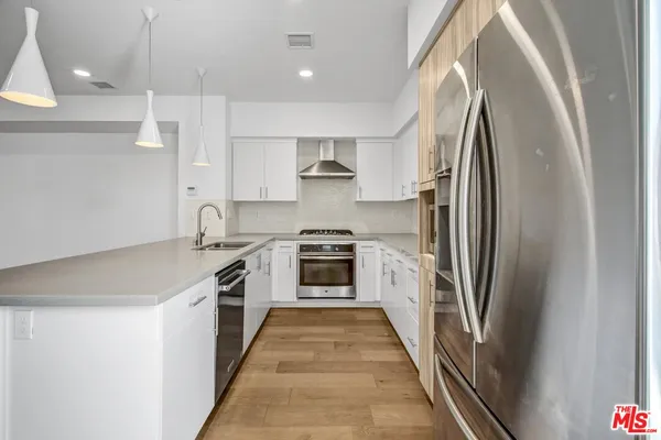 a kitchen with stainless steel appliances granite countertop a refrigerator and a stove top oven