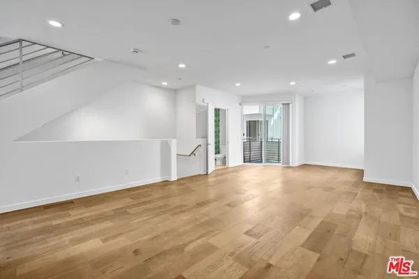 a view of an empty room with wooden floor
