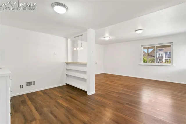 a view of empty room with wooden floor