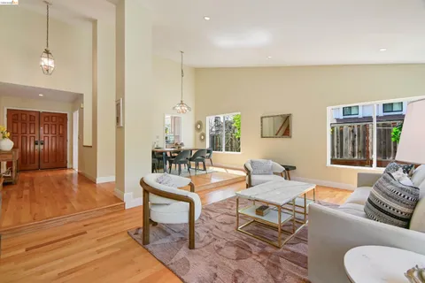 a dining room with wooden floor a chandelier a wooden table and chairs