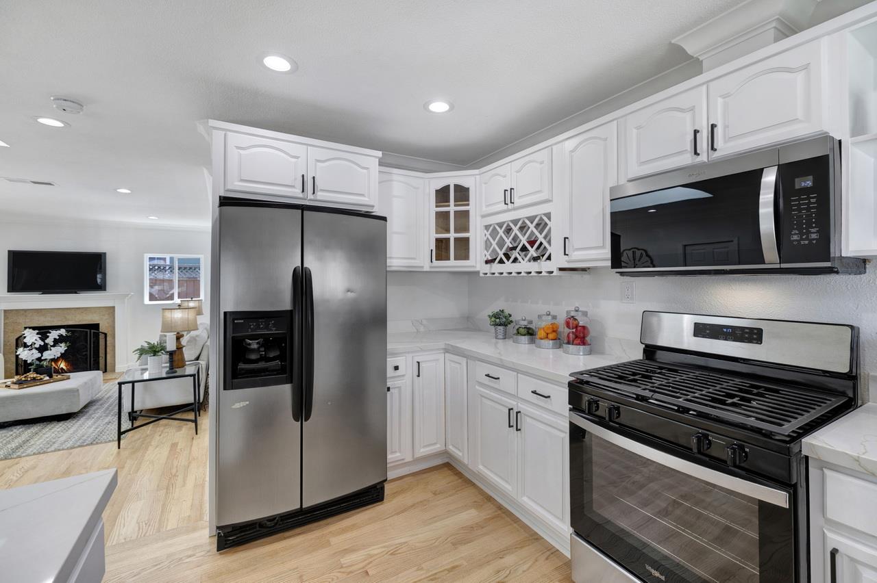 1075 Summerfield Drive San Jose, CA 95121 - Photo 18 of 38 a kitchen with stainless steel appliances a refrigerator a stove top oven a sink dishwasher and white cabinets with wooden floor