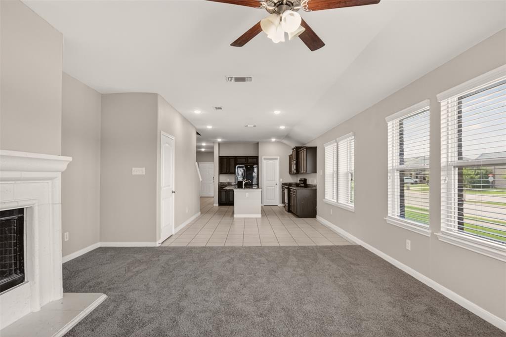 9105 Switchgrass Lane Forney, TX 75126 - Photo 18 of 20 Open-concept living area featuring a white fireplace with mantle, recessed lighting, ceiling fan, and multiple windows with blinds