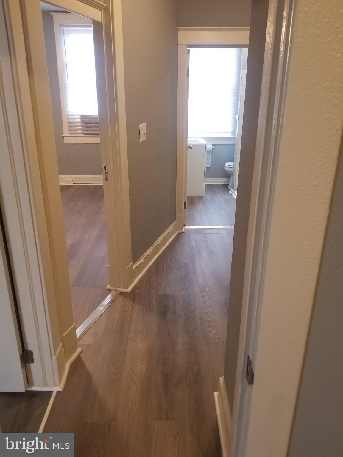 3109 Lawnview Avenue Baltimore, MD 21213 - Photo 13 of 23 a view of a hallway with wooden floor and a bathroom