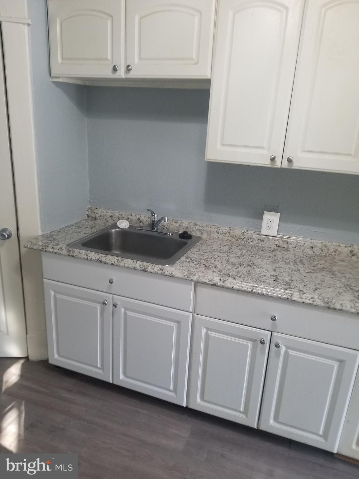3109 Lawnview Avenue Baltimore, MD 21213 - Photo 4 of 23 a kitchen with granite countertop white cabinets and a sink