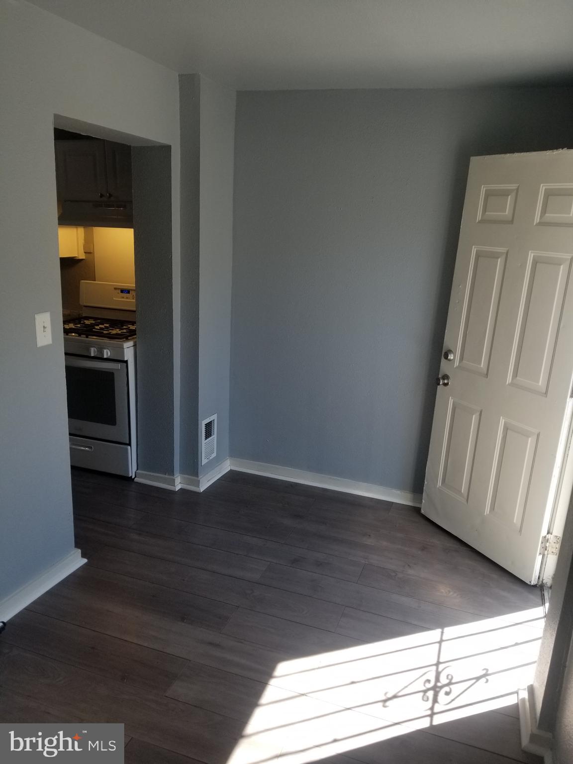 3109 Lawnview Avenue Baltimore, MD 21213 - Photo 8 of 23 a view of empty room with wooden floor and fan