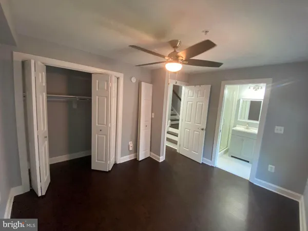 an empty room with wooden floor cabinet and windows