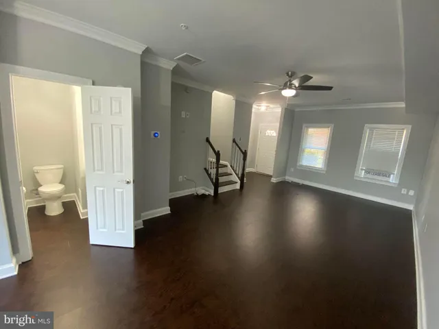 a view of a living room with hardwood floor and a ceiling fan