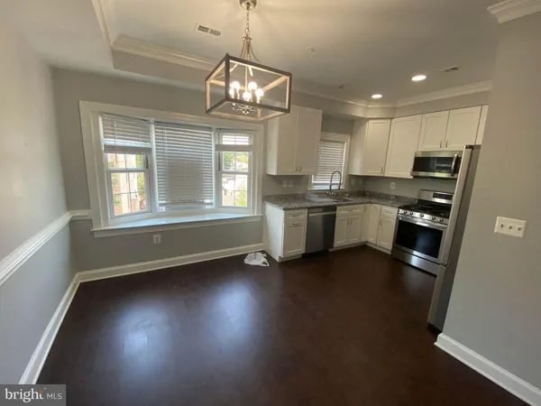 a kitchen with stainless steel appliances granite countertop a stove and a wooden floors