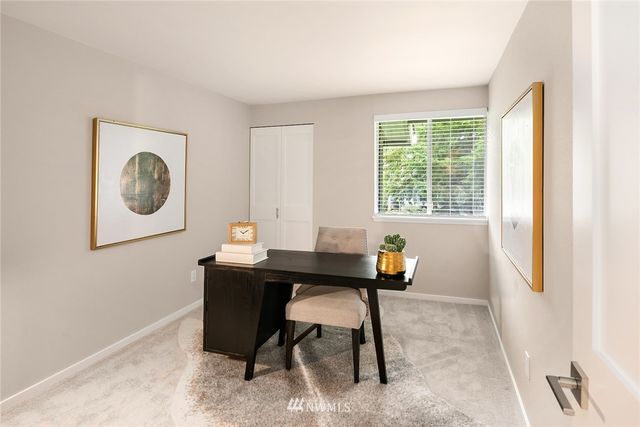 a view of a workspace with furniture and a window
