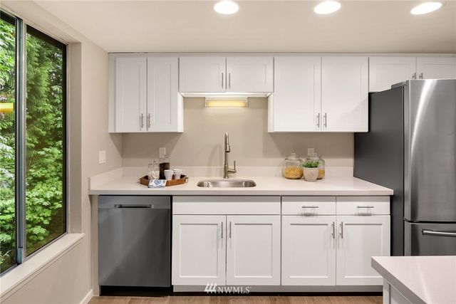 a kitchen with white cabinets and a refrigerator