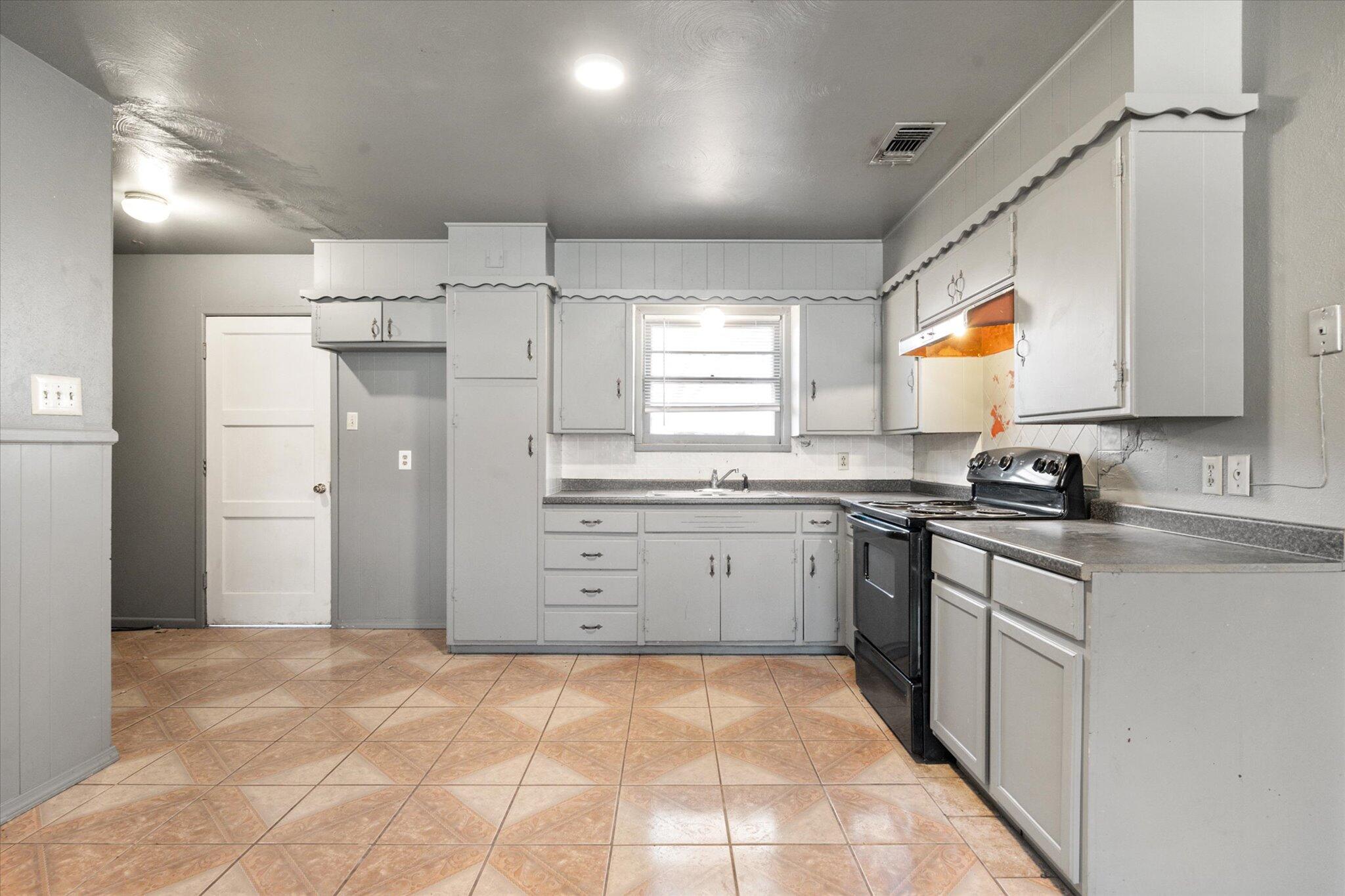 2302 62nd Street Lubbock, TX 79412 - Photo 11 of 38 a kitchen with a refrigerator sink and cabinets