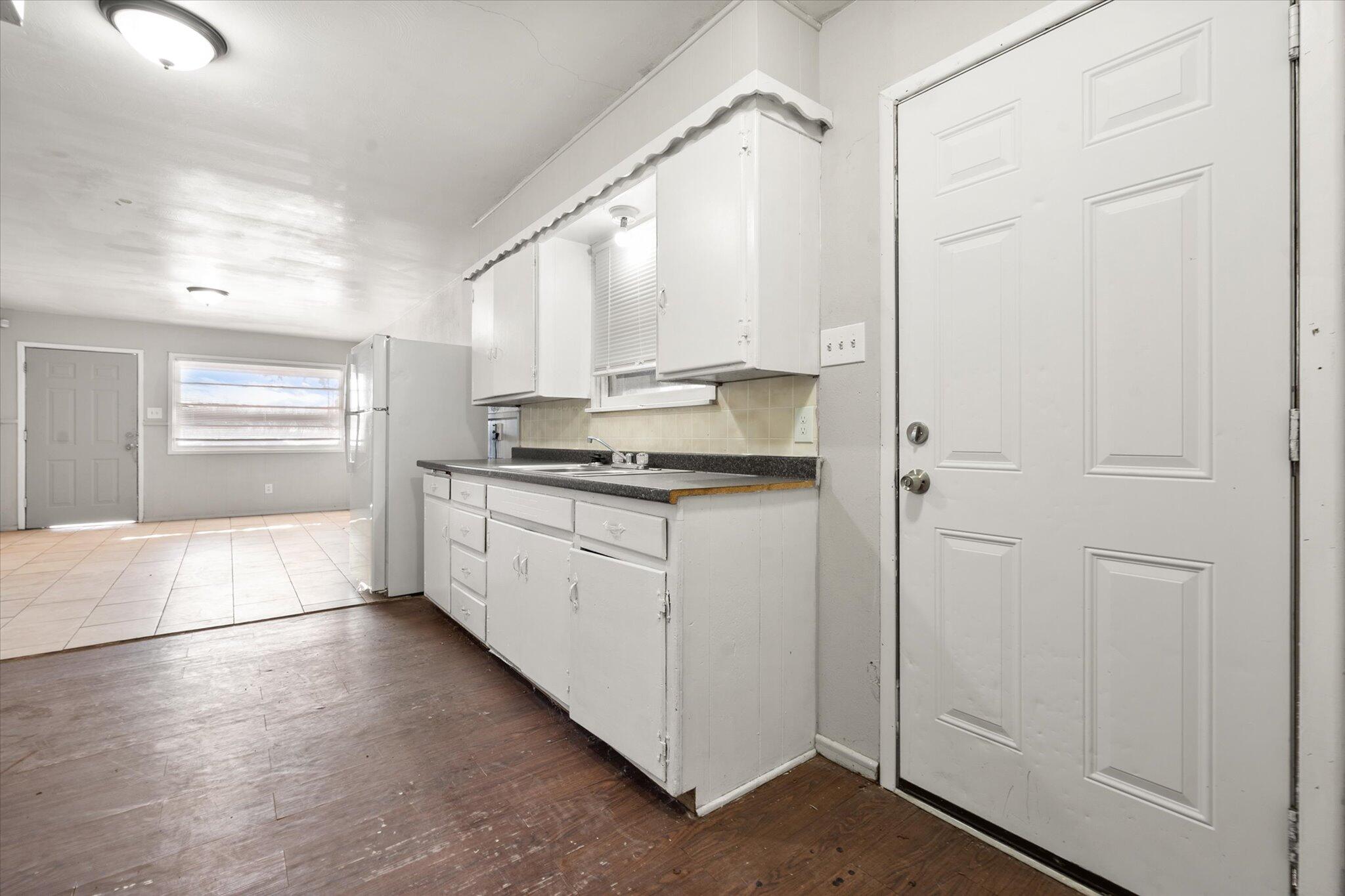 2302 62nd Street Lubbock, TX 79412 - Photo 35 of 38 a kitchen with kitchen island granite countertop white cabinets and white appliances