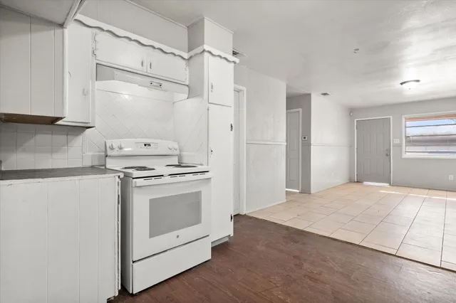 a kitchen with granite countertop white cabinets and white appliances