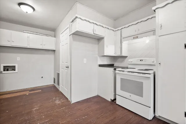 a kitchen with a stove top oven and white cabinets