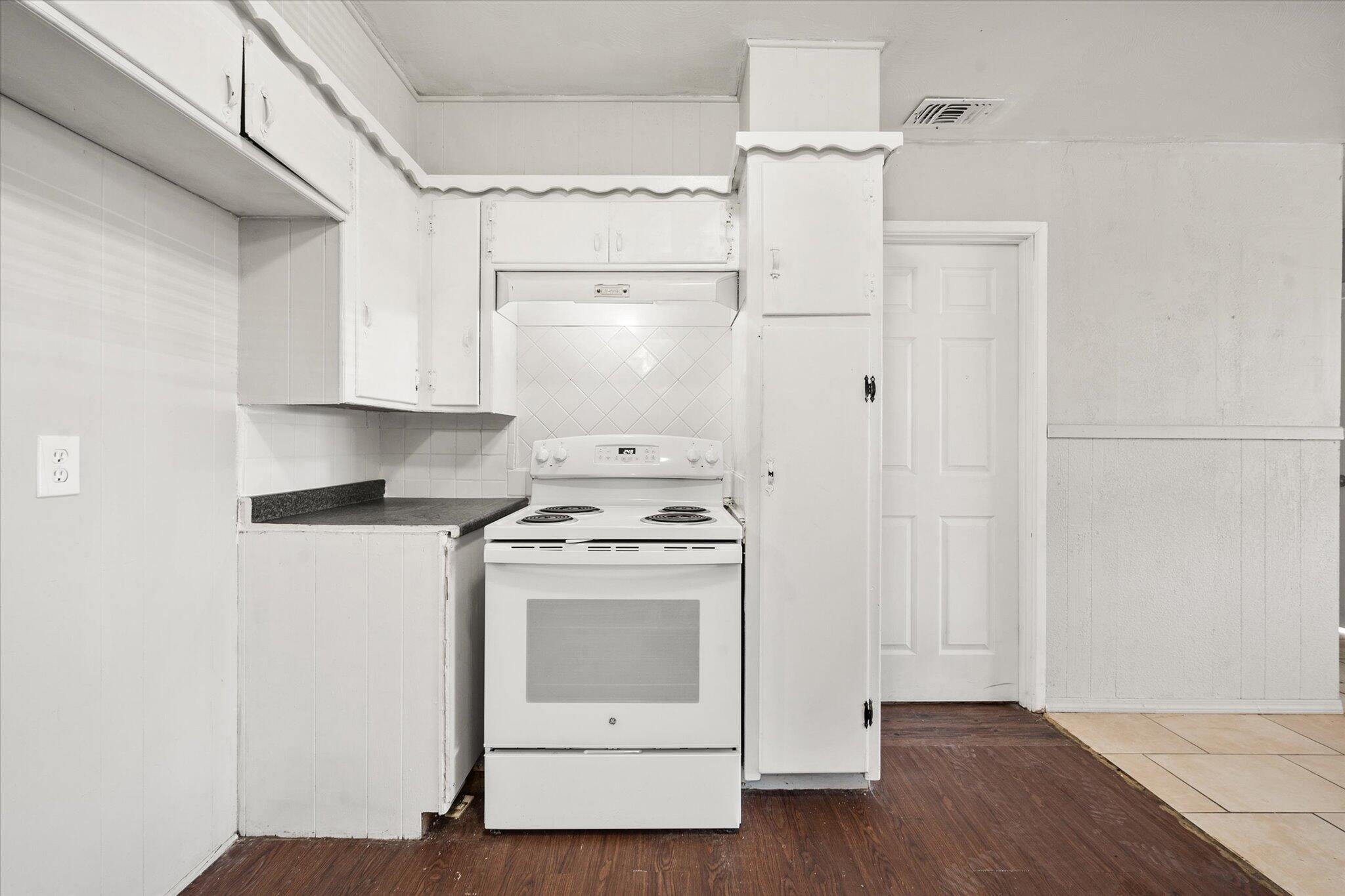2302 62nd Street Lubbock, TX 79412 - Photo 38 of 38 a kitchen with a stove top oven and white cabinets