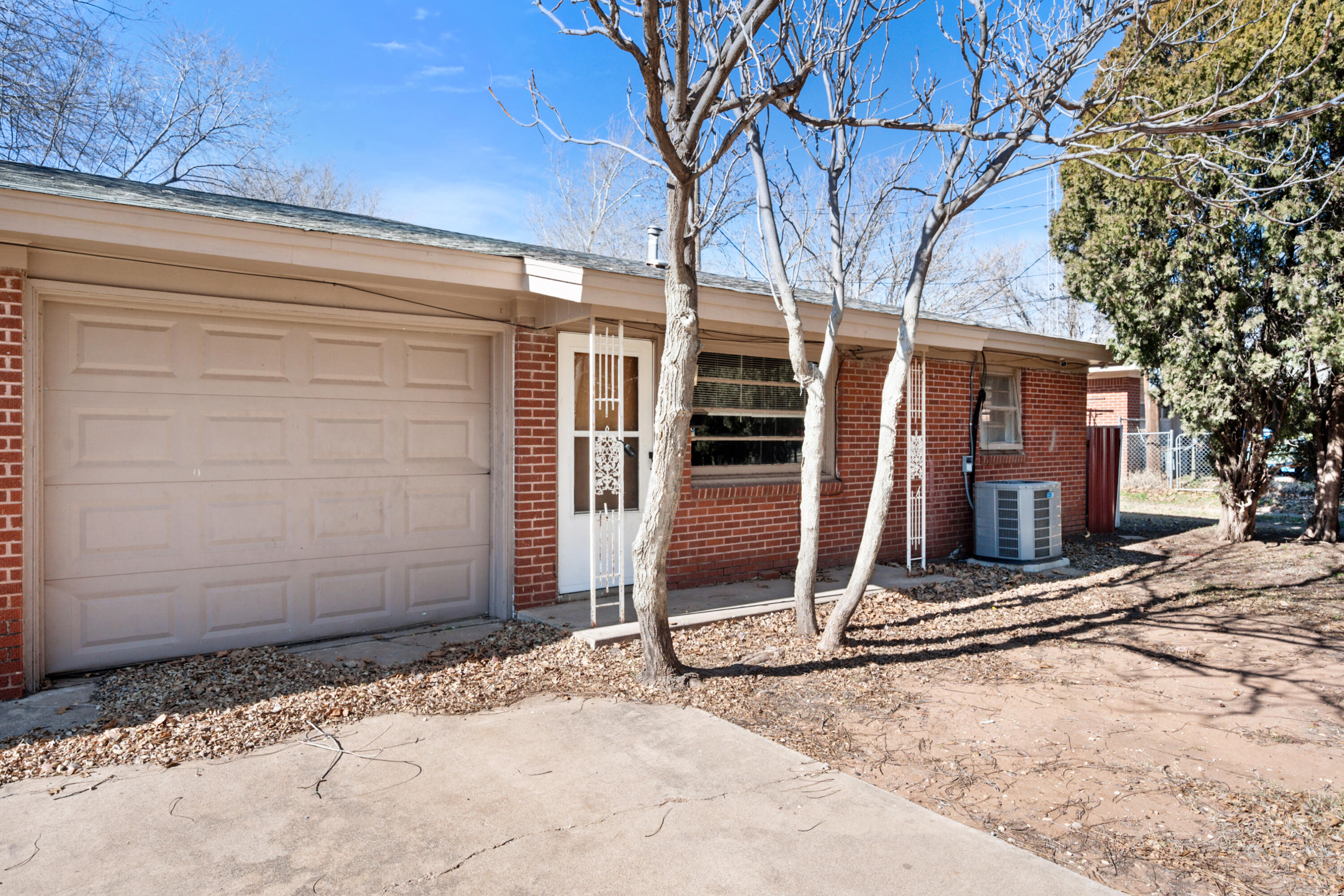 2302 62nd Street Lubbock, TX 79412 - Photo 4 of 38 a view of a wooden house with large tree and wooden fence