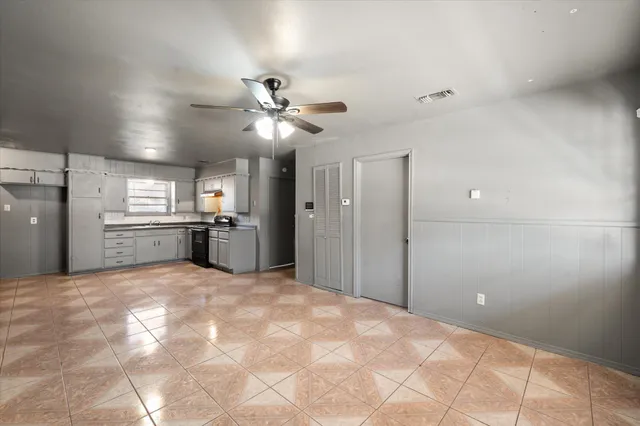 a view of a kitchen with a stove cabinets a ceiling fan and wooden floor