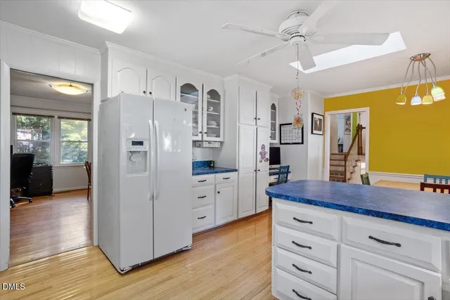 a kitchen with cabinets wooden floor and a large window