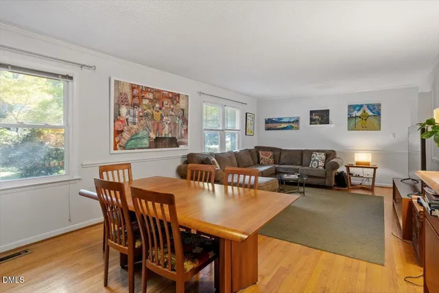 a living room with furniture a large window and a table