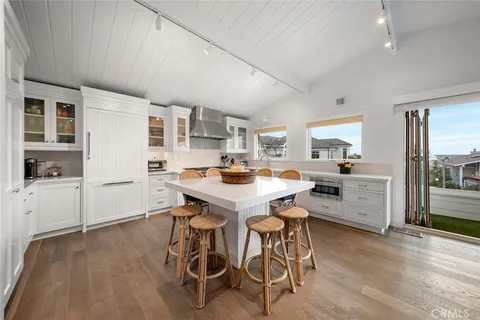 a kitchen with stainless steel appliances a table and chairs in it
