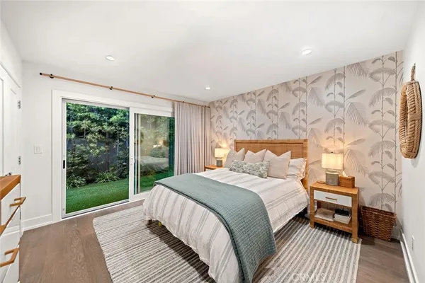 a large living room with stainless steel appliances furniture a rug and a chandelier