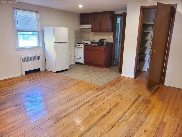 a view of kitchen with refrigerator stove and wooden cabinets