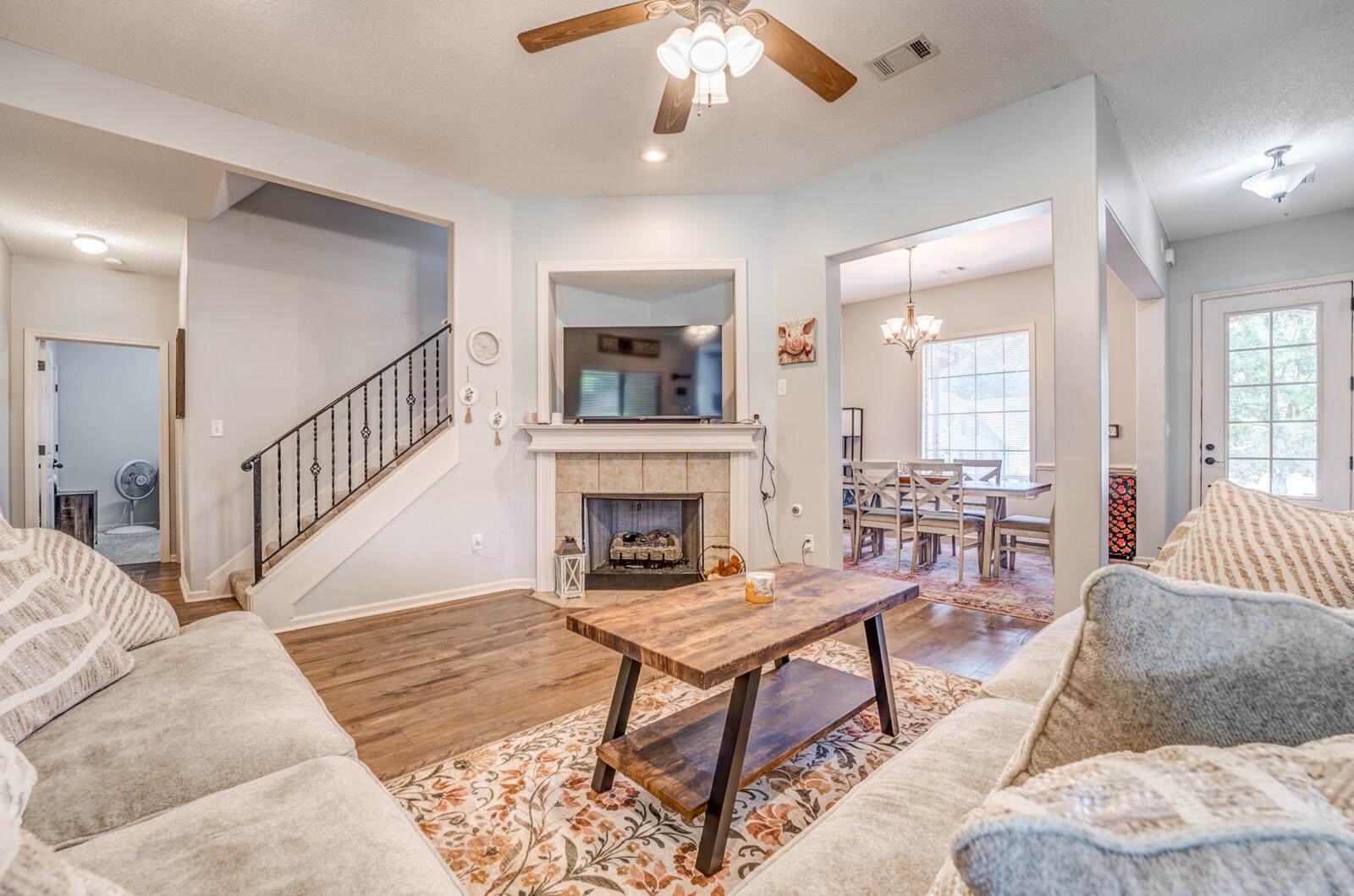 4671 Hampton Ridge Lane Bartlett, TN 38002 - Photo 14 of 40 Living area featuring wood-finish flooring, a ceiling fan with integrated lighting, and a fireplace with a tiled surround and mantel