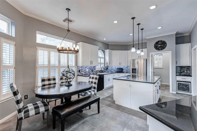 a kitchen with stainless steel appliances kitchen island a table and chairs in it