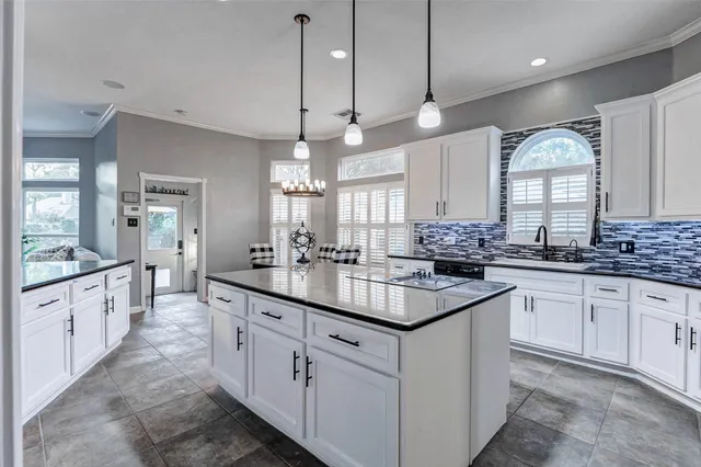 a kitchen with kitchen island granite countertop stainless steel appliances a sink stove and cabinets