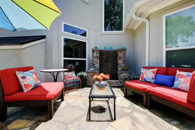 a view of a patio with table and chairs under an umbrella