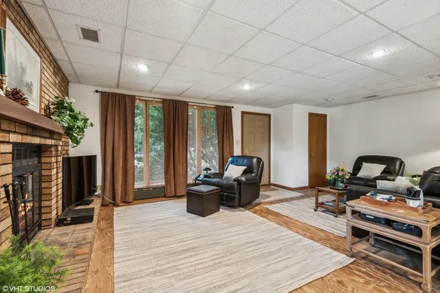 a living room with furniture a large window and wooden floor
