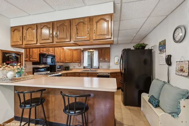 a kitchen with stainless steel appliances granite countertop a refrigerator a stove top oven a sink and cabinets